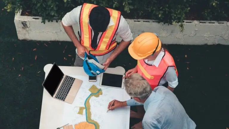 Trois hommes qui discutent sur des documents de chantier
